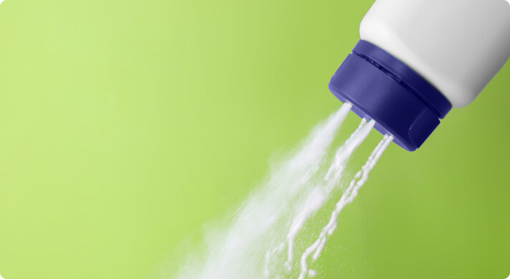 White powder being dispensed from a plastic bottle with a purple cap, set against a bright green background