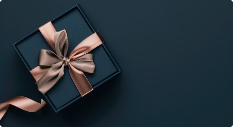 A dark blue gift box tied with a large, silky rose gold ribbon and bow, set against a matching background