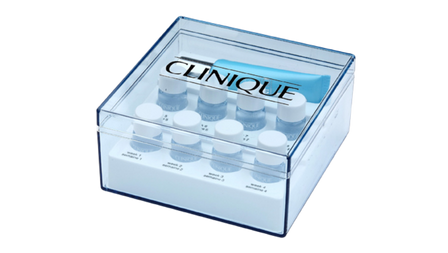 Clear plastic Clinique-branded box containing multiple small skincare sample bottles and a blue applicator tool