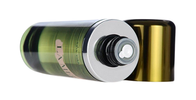 Open La Mer skincare bottle lying on its side, revealing the nozzle and metallic gold cap beside it